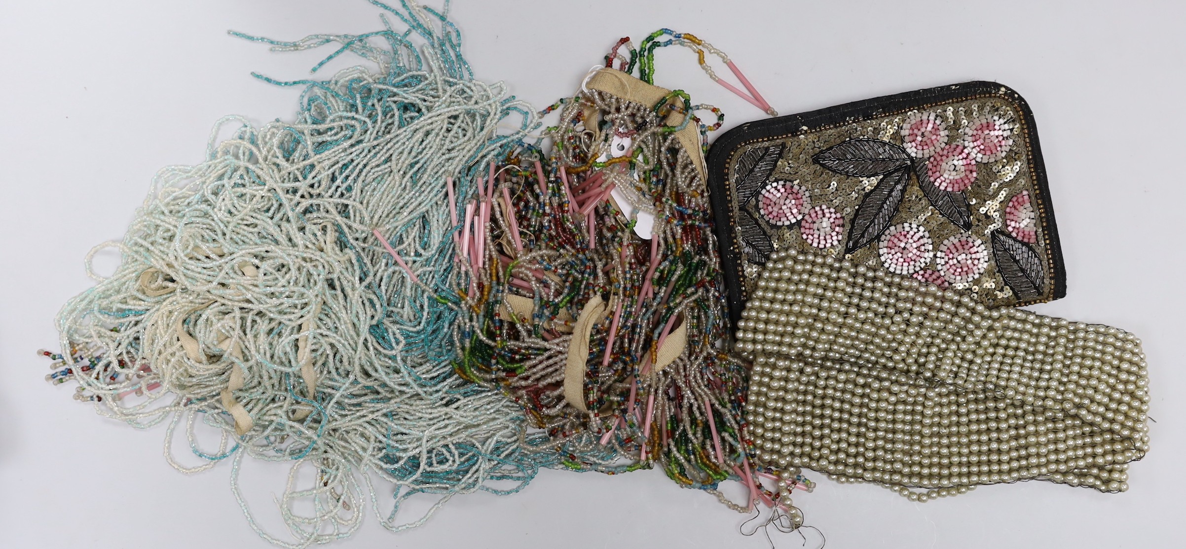An oak box containing a mixed collection of decorative jet and coloured beaded trimmings, inserts, panels and fringing etc.